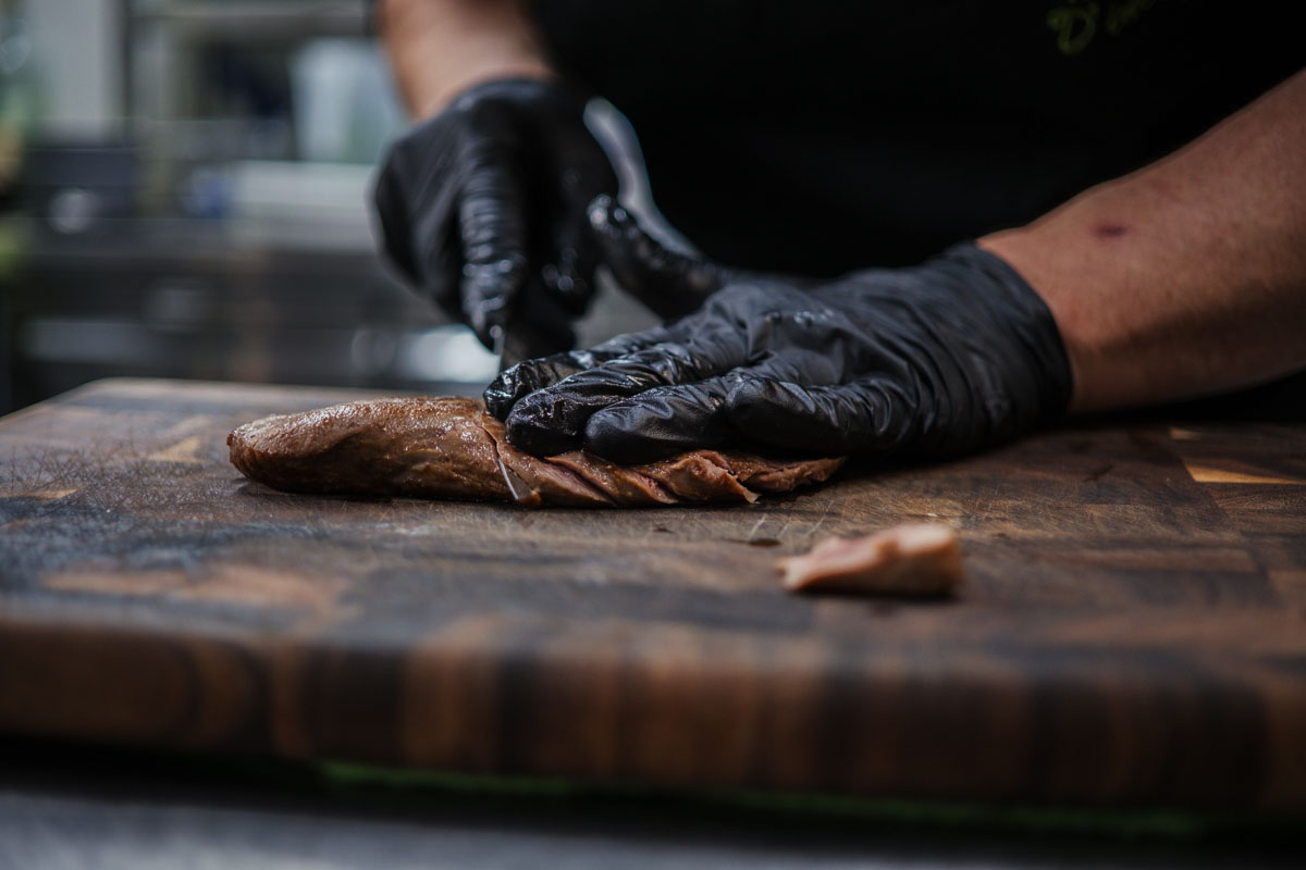 Preparazione artigianale della carne nella cucina del ristorante Terre di Giorgio
